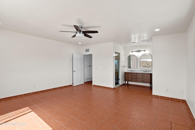 unfurnished bedroom with baseboards, connected bathroom, recessed lighting, a sink, and tile patterned flooring