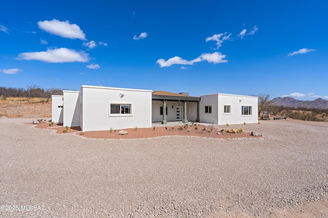 view of front of house featuring stucco siding and a mountain view