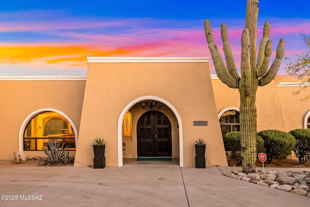entrance to property featuring french doors and stucco siding