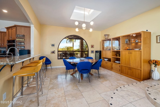 dining room featuring a skylight and baseboards