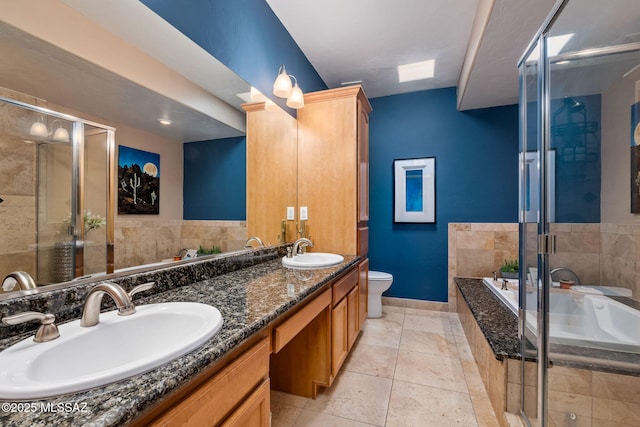 full bathroom with baseboards, a sink, a bath, and a stall shower
