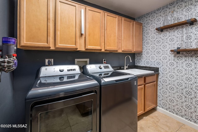 laundry room with a sink, light tile patterned floors, cabinet space, and washer and dryer