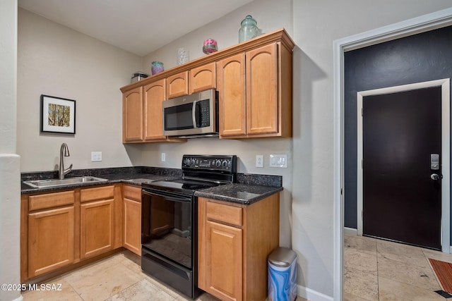 kitchen featuring a sink, baseboards, stainless steel microwave, black range with electric stovetop, and stone tile flooring