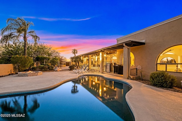 outdoor pool featuring a patio, an outdoor fire pit, and central AC