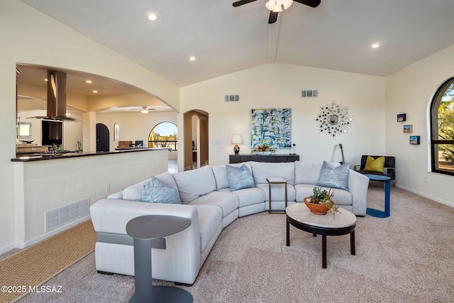living room featuring arched walkways, ceiling fan, light carpet, and visible vents