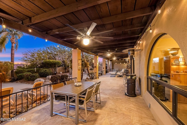 patio terrace at dusk featuring a ceiling fan and outdoor dining area