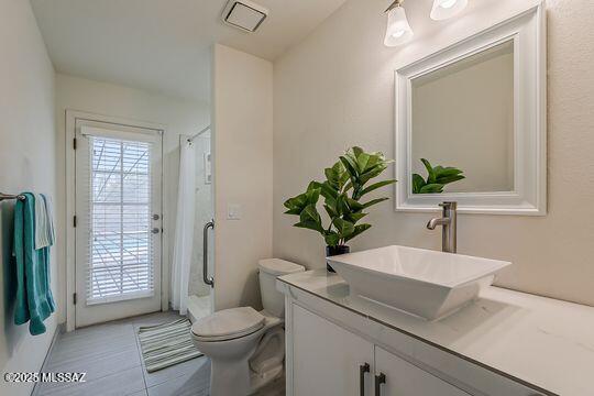 bathroom with a shower with curtain, visible vents, toilet, and vanity