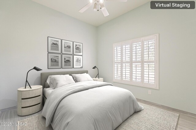 bedroom featuring baseboards, light wood-type flooring, and ceiling fan