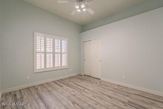 unfurnished room featuring wood finished floors, baseboards, and ceiling fan