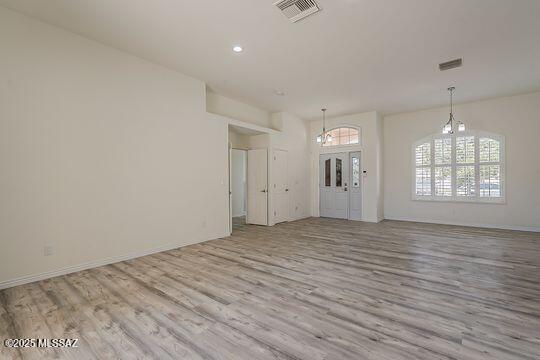 unfurnished living room featuring visible vents, a chandelier, recessed lighting, and wood finished floors