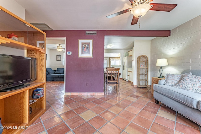 tiled living room featuring baseboards, ceiling fan, visible vents, and beam ceiling