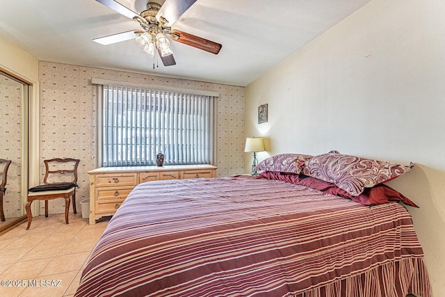 bedroom with light tile patterned flooring, wallpapered walls, and a ceiling fan
