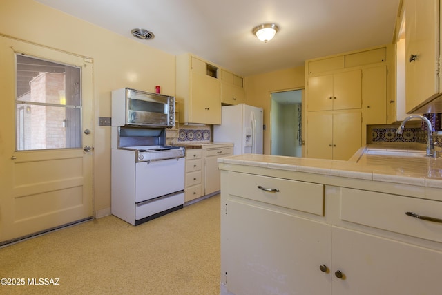 3256 E Terra Alta Blvd, Tucson, AZ 85716 - kitchen with white appliances, a sink, tile countertops, a peninsula, and cream cabinetry