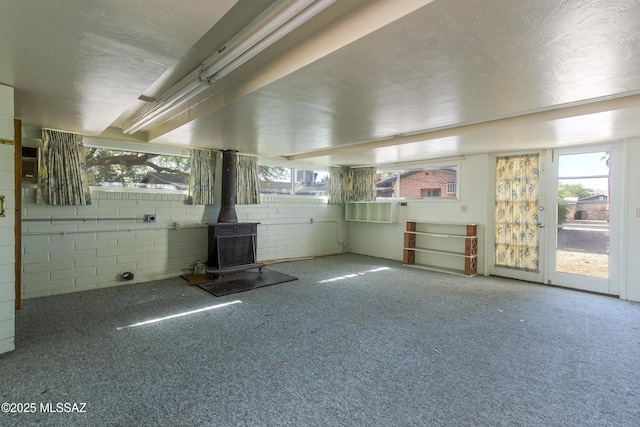 3256 E Terra Alta Blvd, Tucson, AZ 85716 - interior space featuring a wood stove, carpet flooring, plenty of natural light, and a textured ceiling