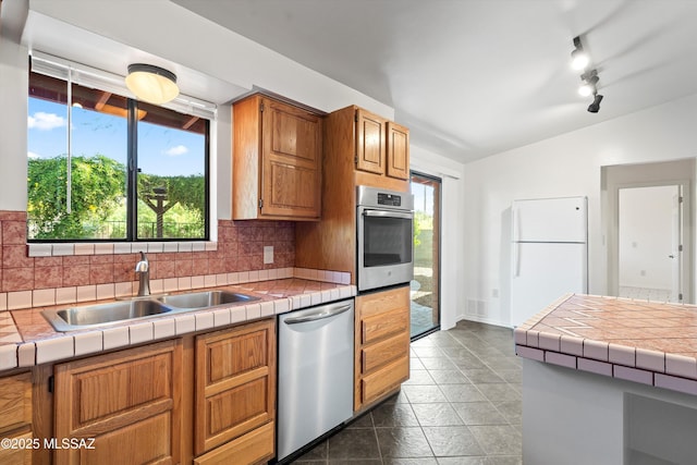 kitchen featuring decorative backsplash, stainless steel appliances, a sink, and lofted ceiling