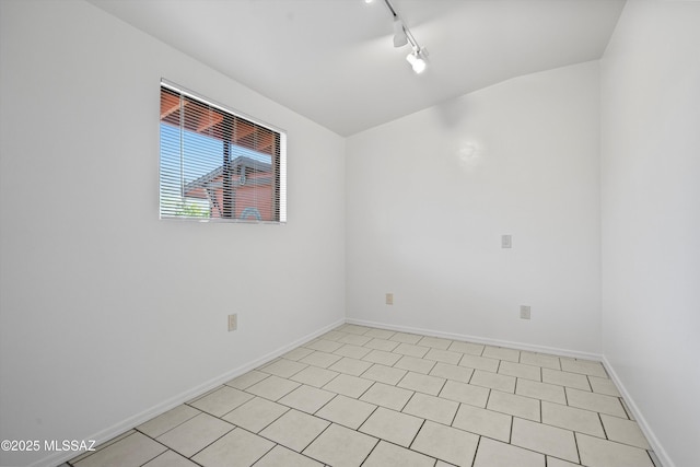 empty room with rail lighting and baseboards