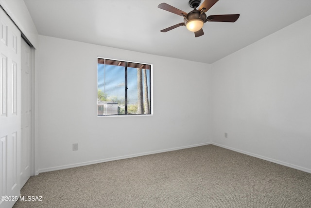 unfurnished bedroom with baseboards, a ceiling fan, carpet flooring, and a closet