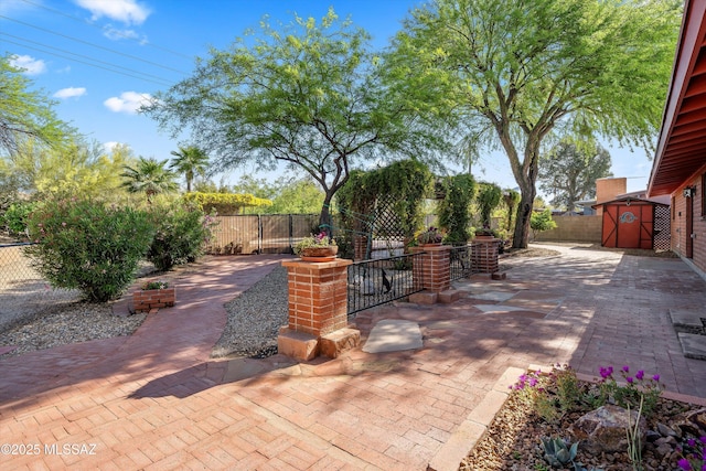 view of patio with a fenced backyard, a storage unit, and an outdoor structure