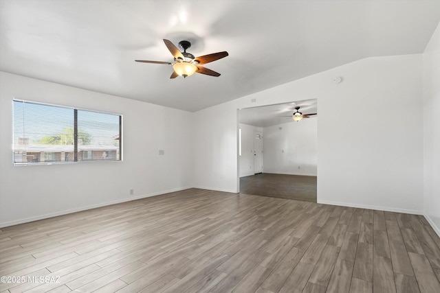 spare room with lofted ceiling, a ceiling fan, and wood finished floors