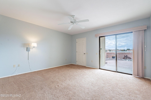 carpeted spare room featuring a ceiling fan and baseboards