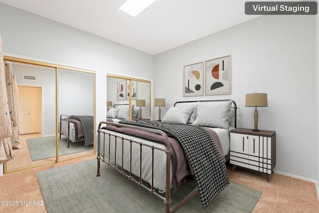 carpeted bedroom featuring baseboards, visible vents, two closets, and a skylight