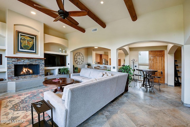 living room featuring a ceiling fan, visible vents, beamed ceiling, and recessed lighting