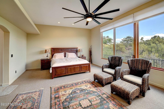 bedroom featuring light carpet, arched walkways, baseboards, recessed lighting, and a ceiling fan