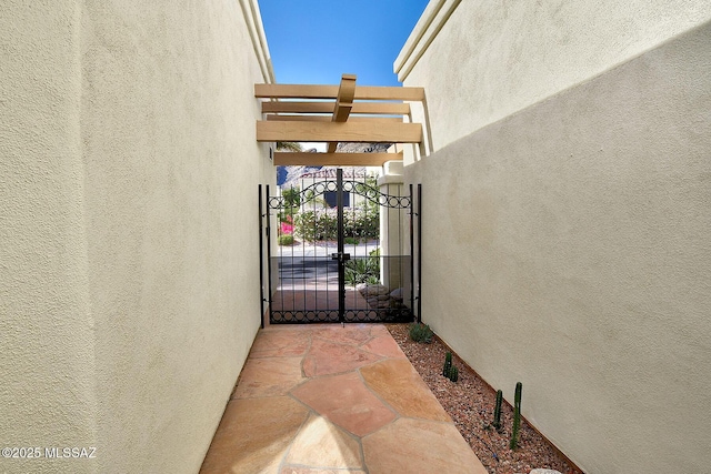 exterior space featuring a gate and stucco siding