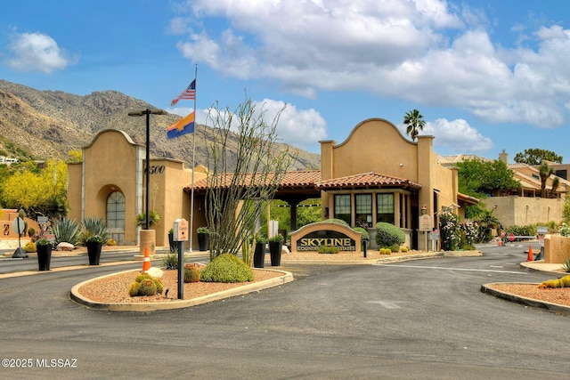 view of building exterior with uncovered parking and a mountain view
