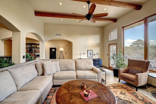 living area with recessed lighting, visible vents, arched walkways, beam ceiling, and ceiling fan