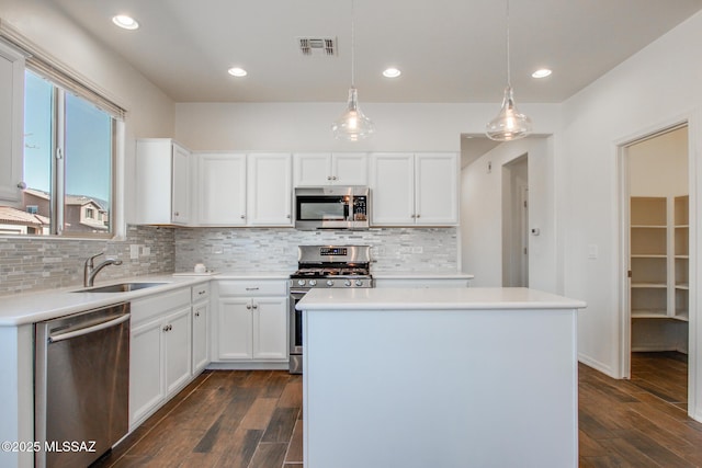 kitchen featuring dark wood-style floors, appliances with stainless steel finishes, a sink, and visible vents