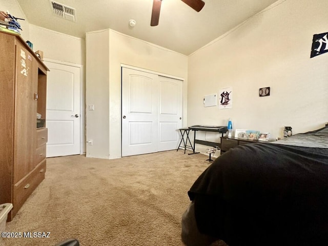 bedroom featuring ceiling fan, a closet, visible vents, carpet flooring, and lofted ceiling