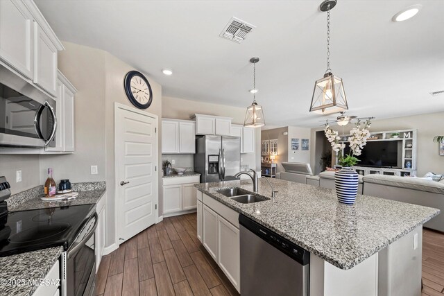 kitchen with visible vents, a sink, dark wood-type flooring, appliances with stainless steel finishes, and open floor plan