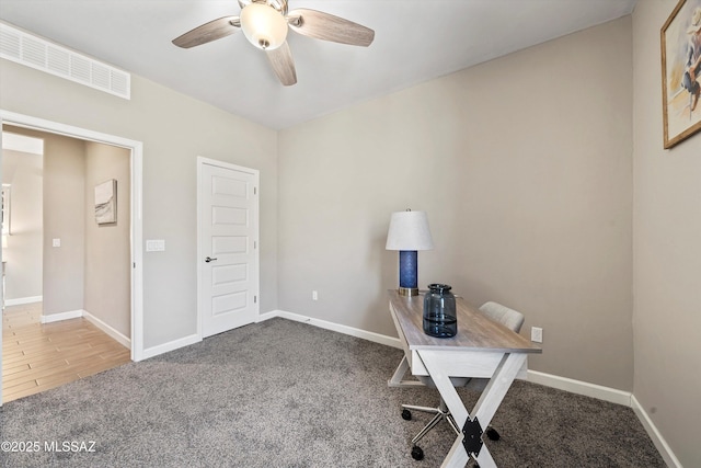 unfurnished office featuring ceiling fan, carpet floors, and baseboards