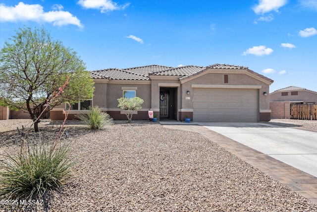 view of front of property with a garage, a tile roof, stucco siding, and driveway