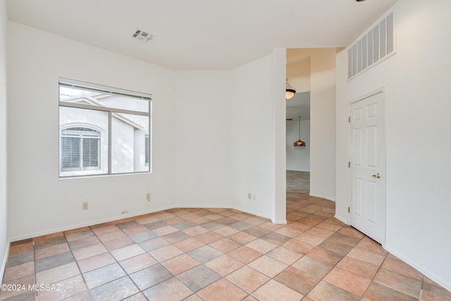 spare room with light tile patterned floors, visible vents, and baseboards