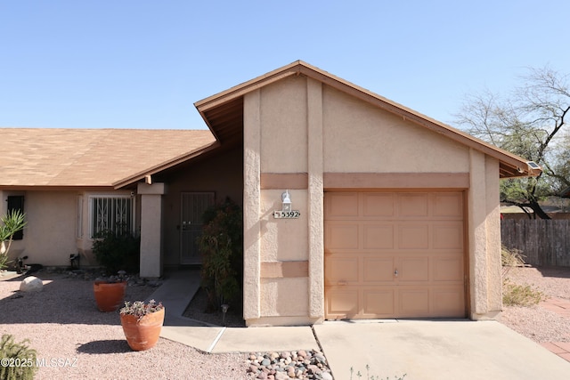 garage featuring driveway and fence
