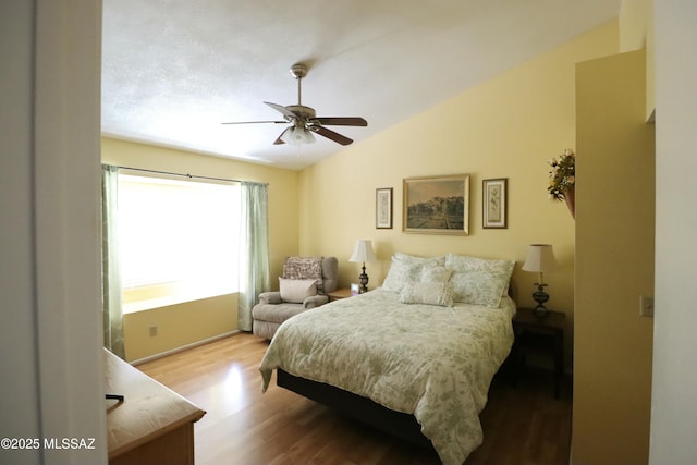 bedroom featuring wood finished floors, a ceiling fan, and vaulted ceiling