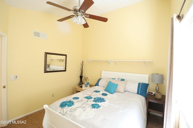 tiled bedroom with visible vents, ceiling fan, and baseboards