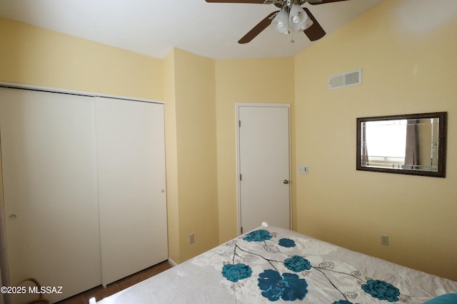 unfurnished bedroom with a closet, a ceiling fan, vaulted ceiling, tile patterned flooring, and visible vents