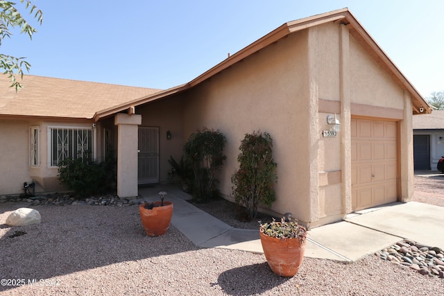 view of front of house with a garage and stucco siding