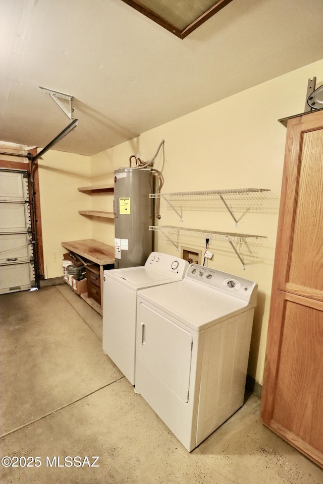 washroom featuring water heater, independent washer and dryer, a garage, and laundry area