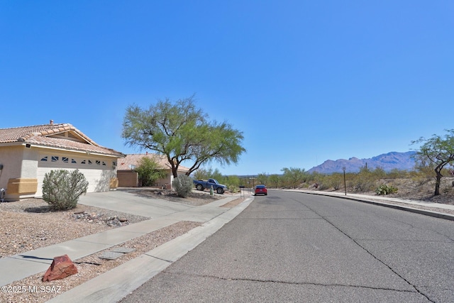 3625 N Avenida Albor, Tucson, AZ 85745 - view of asphalt road with sidewalks, a mountain view, and curbs