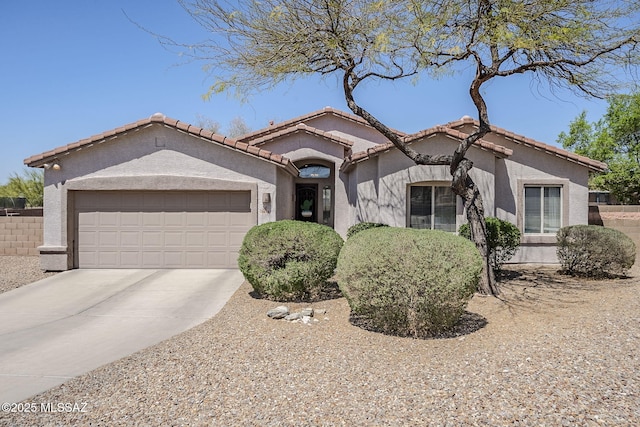 view of front facade featuring fence, a garage, stucco siding, a tiled roof, and driveway