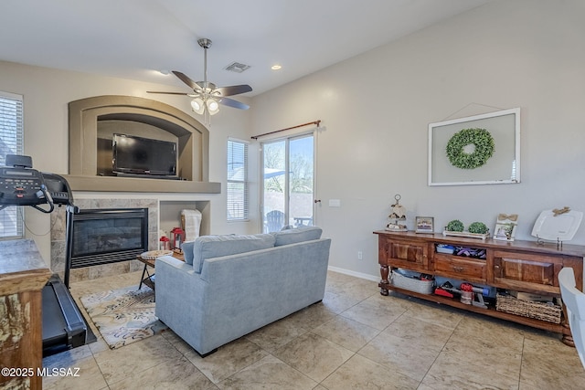 living area with visible vents, baseboards, a tile fireplace, a ceiling fan, and light tile patterned floors