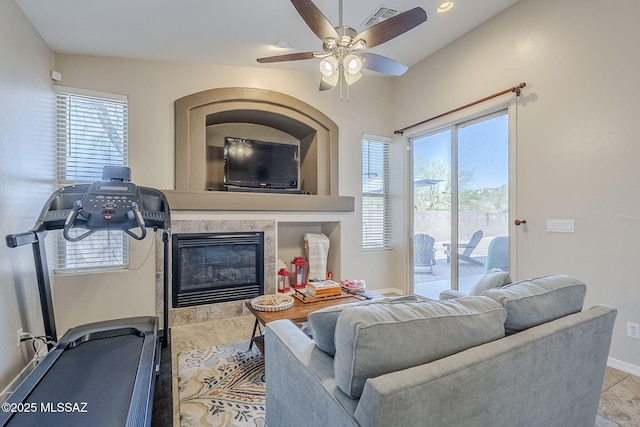 living room featuring a ceiling fan, baseboards, visible vents, and plenty of natural light