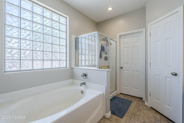full bath with plenty of natural light, a shower stall, and a garden tub