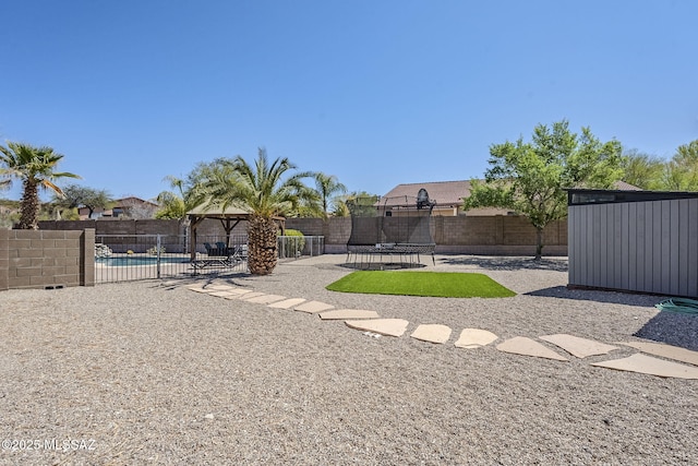 view of yard featuring a gazebo, a fenced backyard, and a trampoline