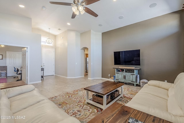 living room featuring arched walkways, high vaulted ceiling, a ceiling fan, recessed lighting, and baseboards