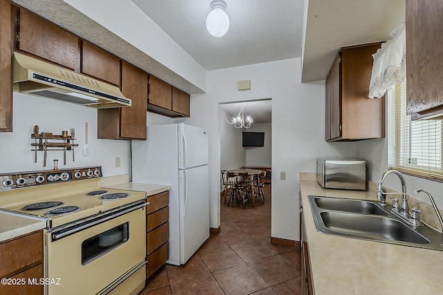 221 N Calle Del Lago, Green Valley, AZ 85614 - kitchen with under cabinet range hood, white appliances, light countertops, and a sink